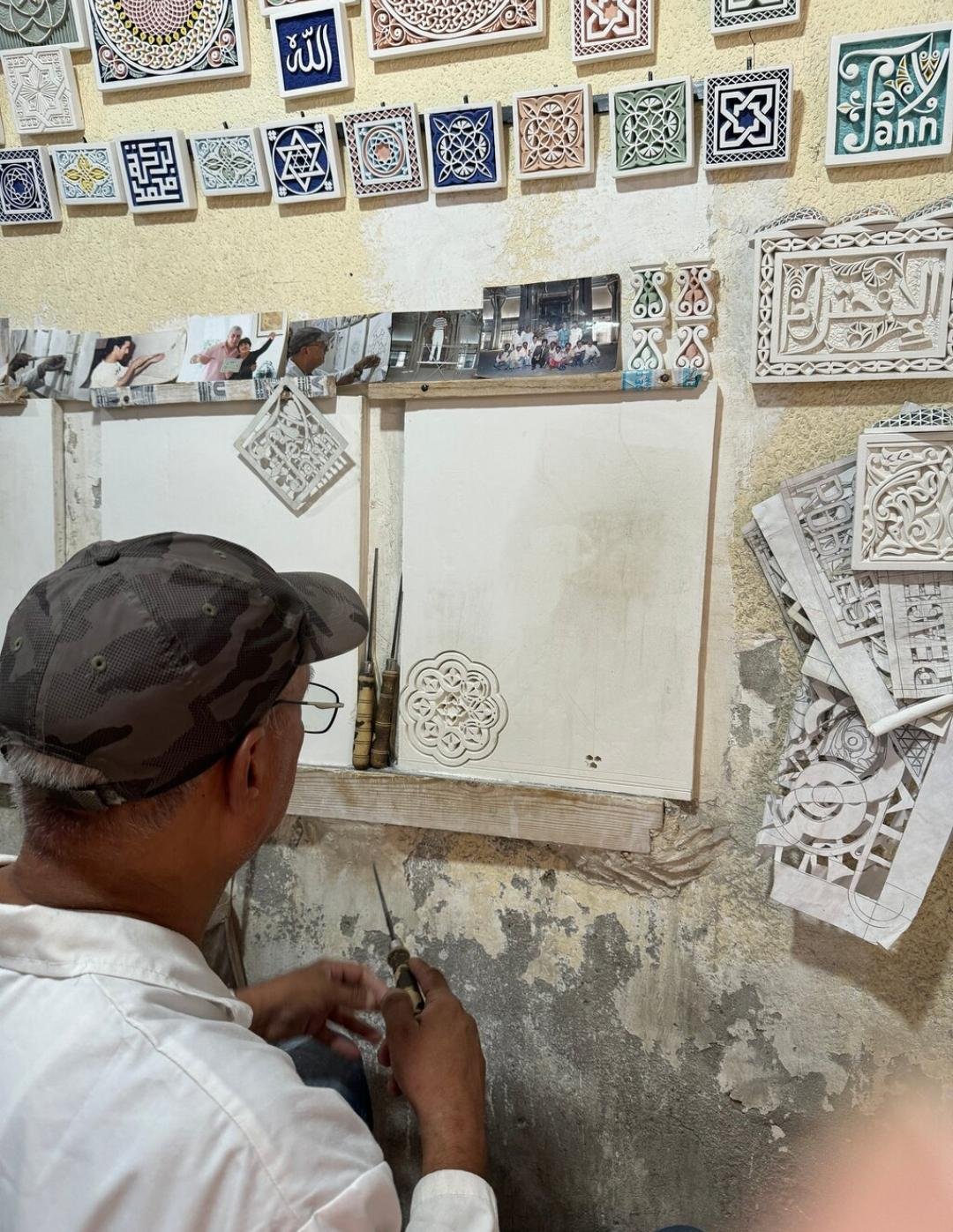 Moroccan artisan carving traditional plaster by hand in Marrakech Medina