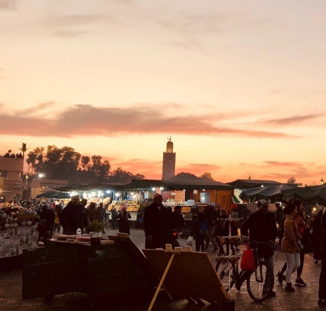 Warm orange-lit scene in Marrakech medina at night
