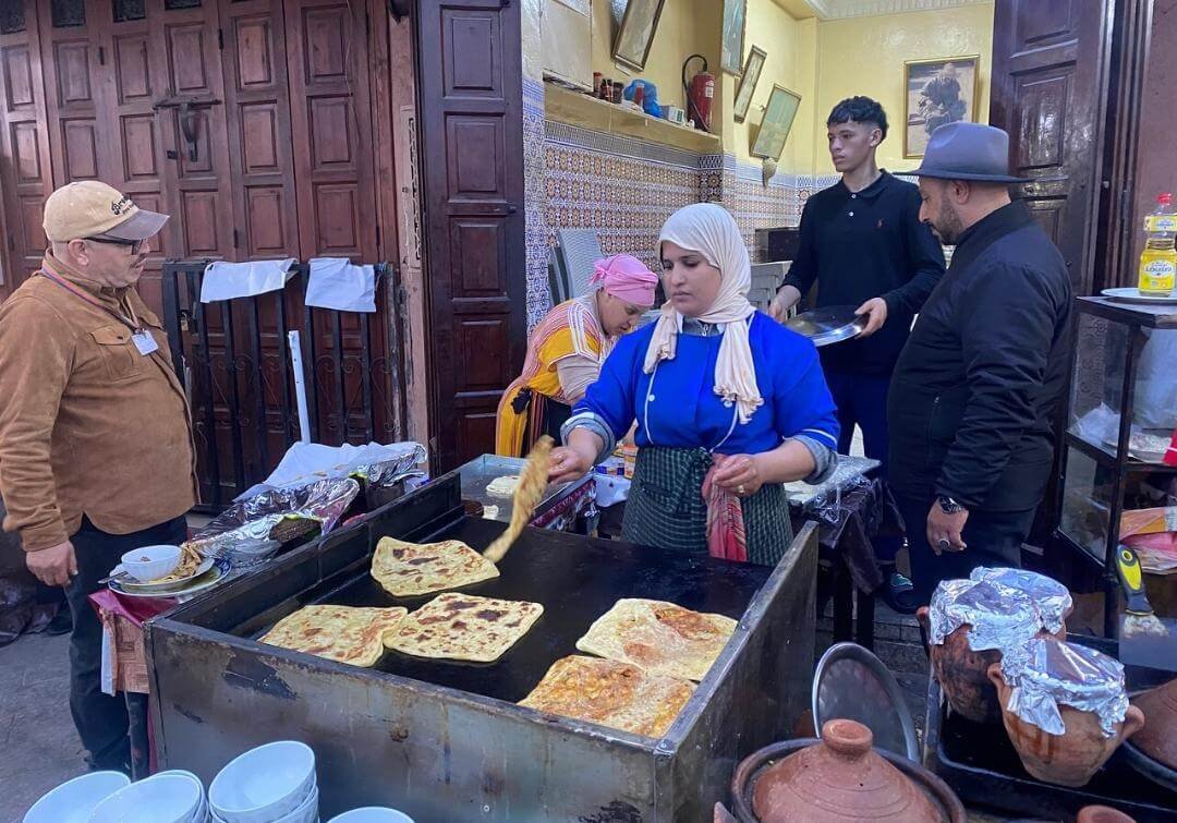 Vendor preparing msemen at a Marrakech street stall