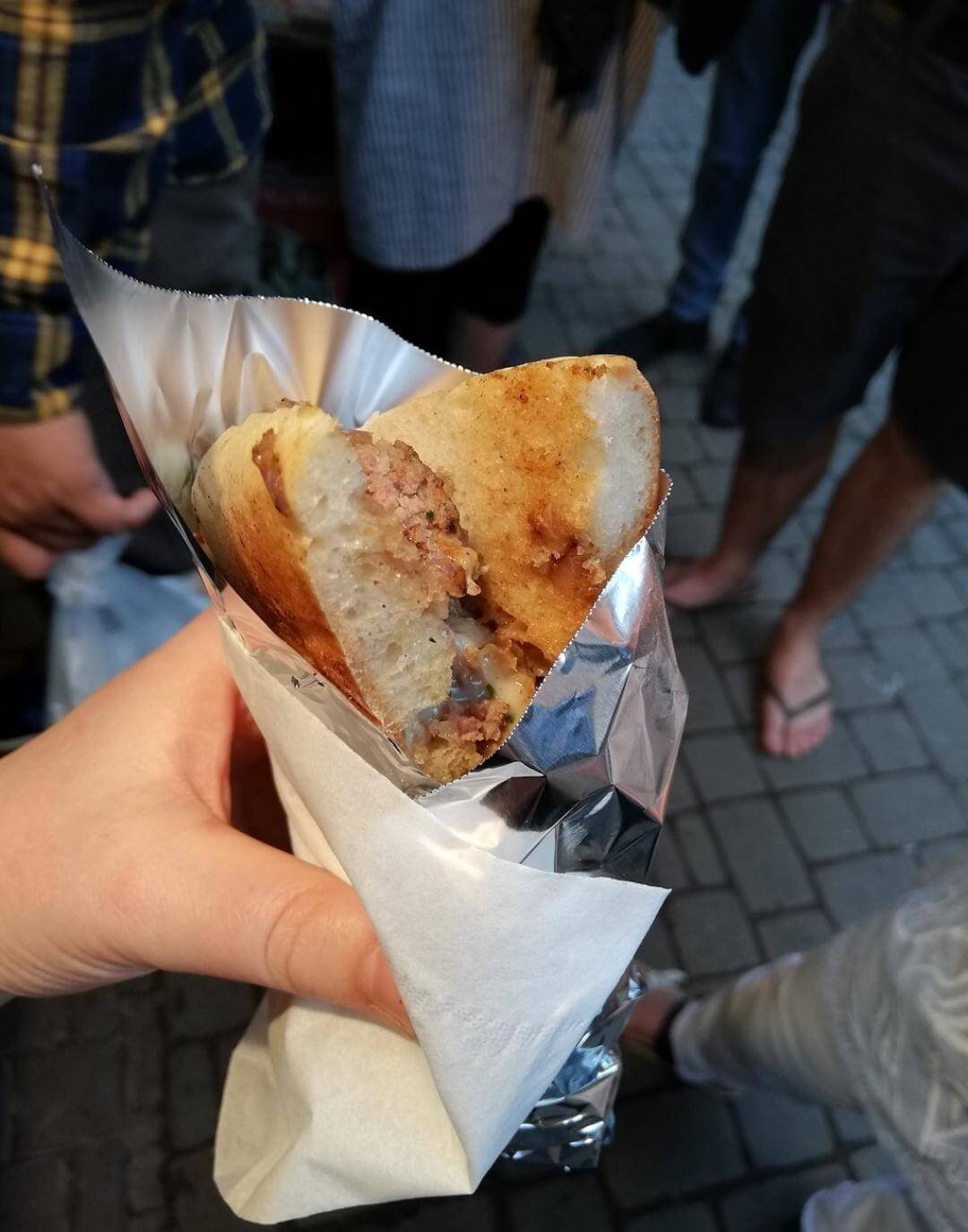 Hand holding a wrapped Moroccan street food snack