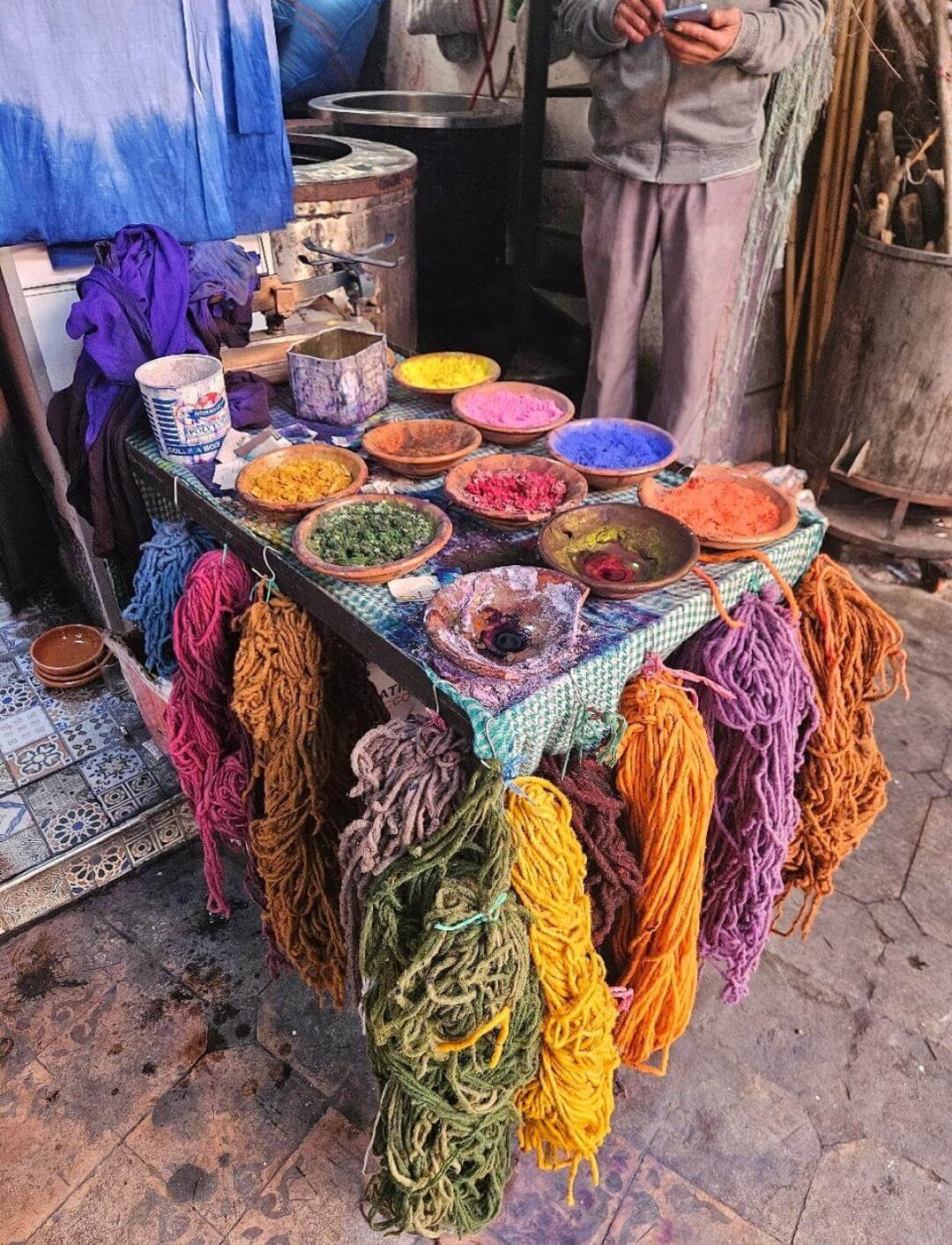 Colorful pottery and dyed wool display in Marrakech souk