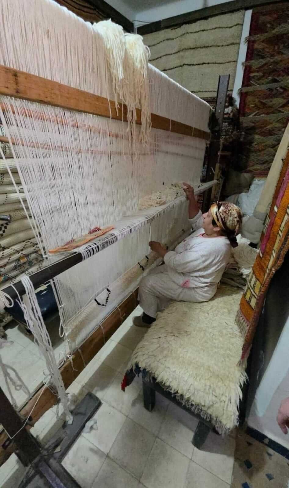 Local woman weaving a traditional Moroccan rug in Marrakech