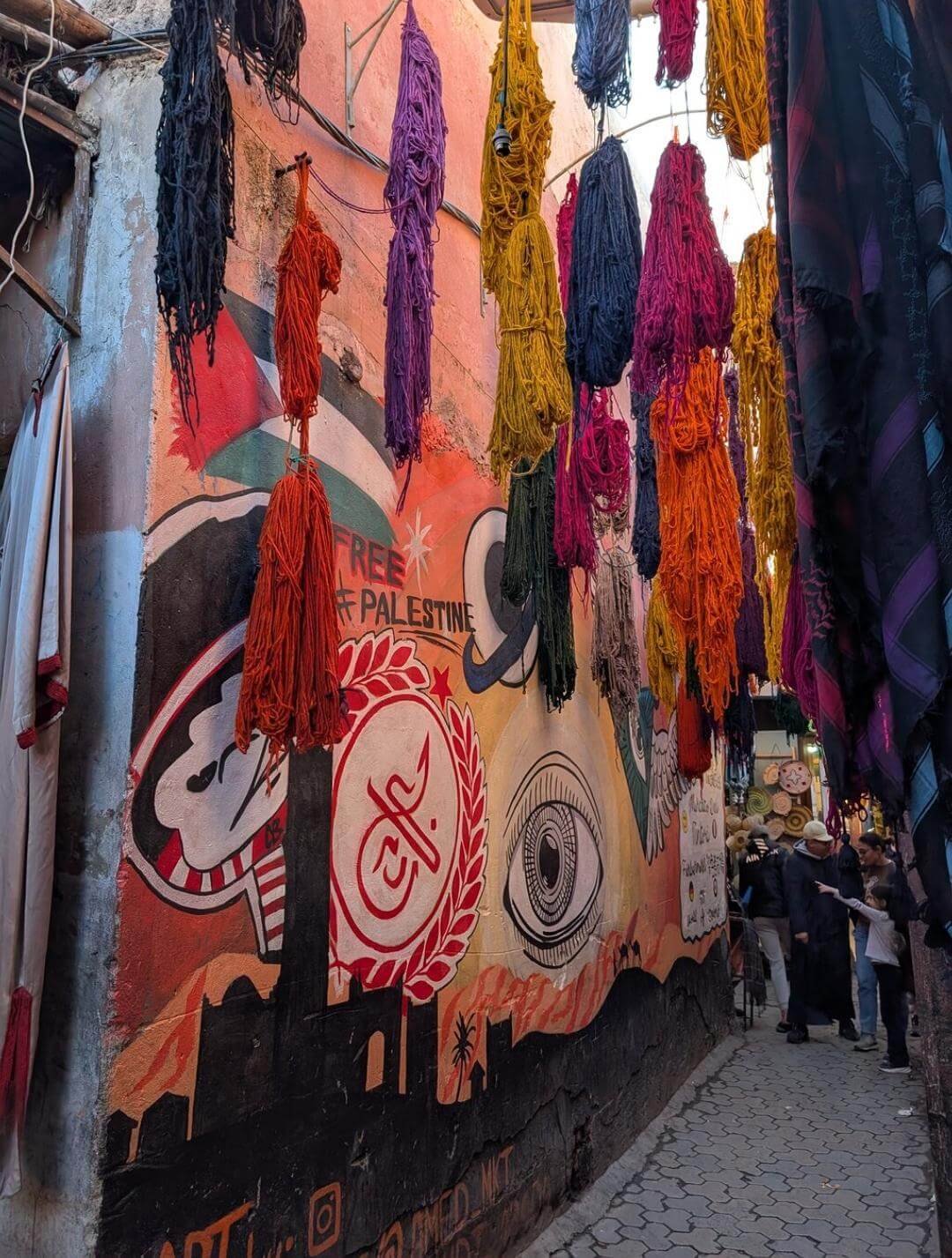 Dyed fabrics hanging in a Marrakech souk alley