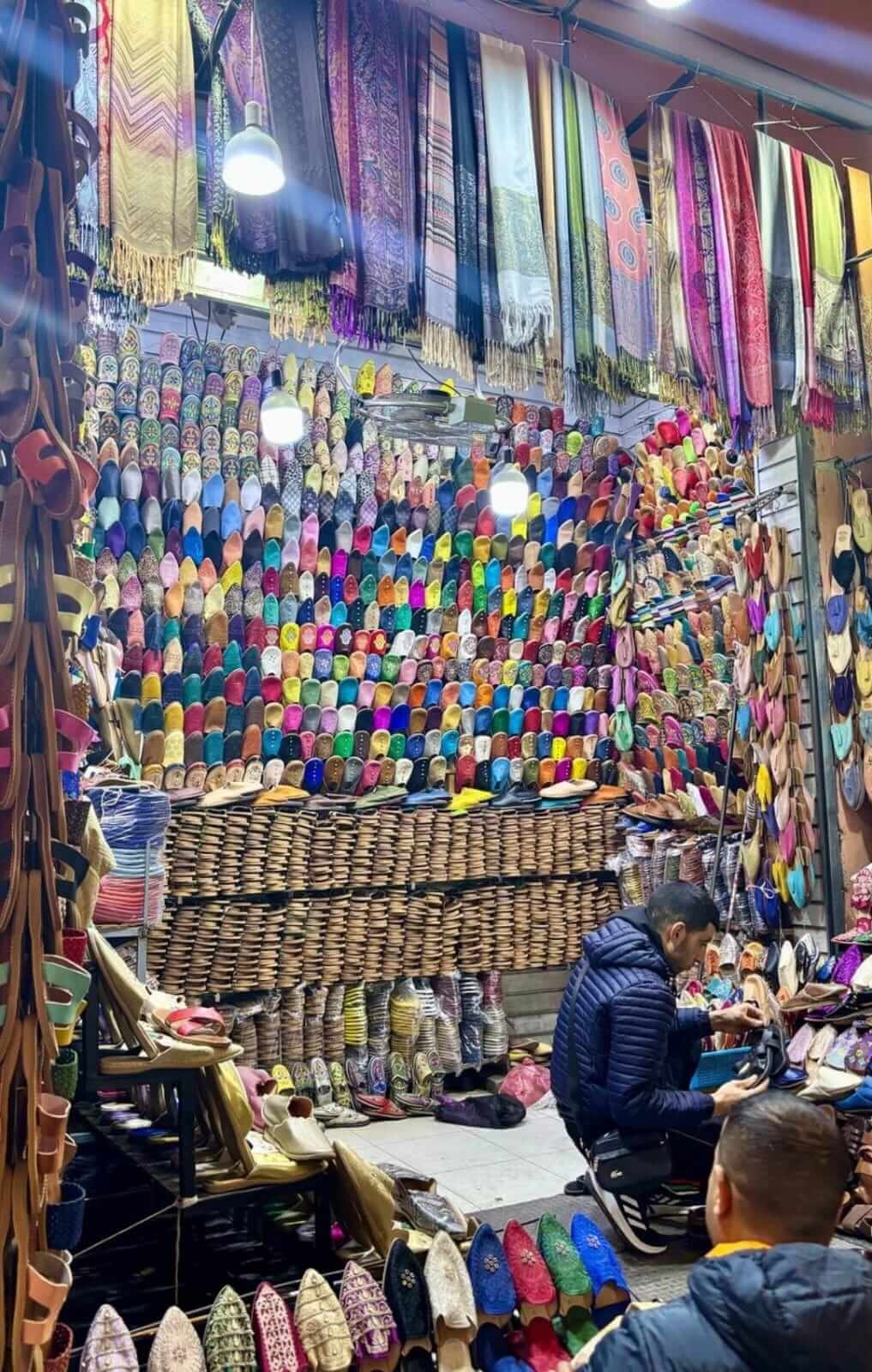 Busy souk alley with shops in Marrakech medina