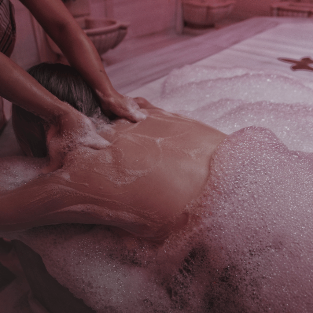 Traditional Moroccan hammam gommage — black soap scrub treatment during a spa experience in Marrakech