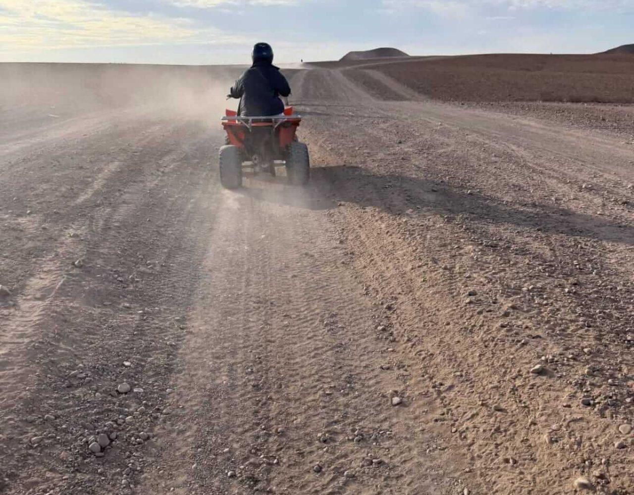 Quad bike rider on a dusty desert trail in Agafay