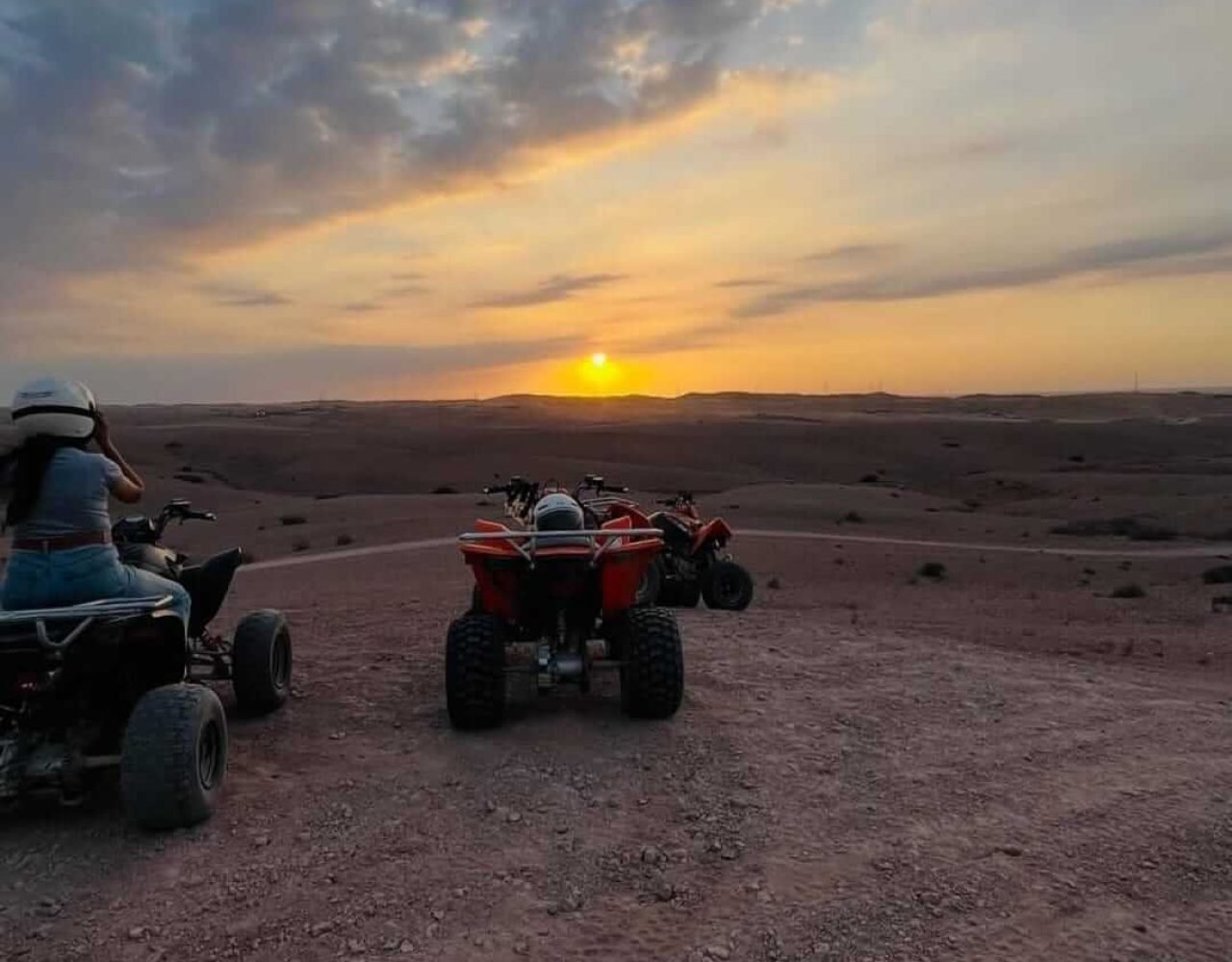 Quad bikes riding through the Agafay Desert at sunset