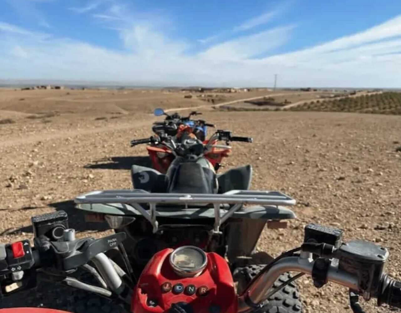 Quad bikes parked in the Agafay Desert under a clear sky