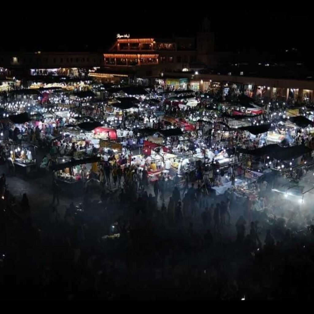 Aerial view of Jemaa el-Fnaa square lit up at night in Marrakech