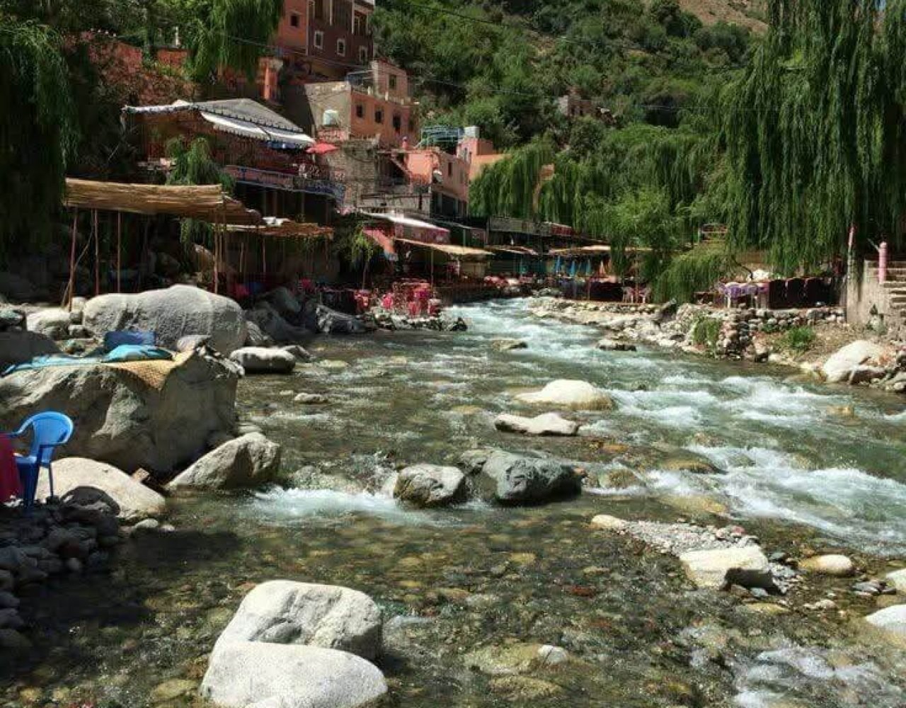 Ourika river flowing between rocks next to traditional restaurants