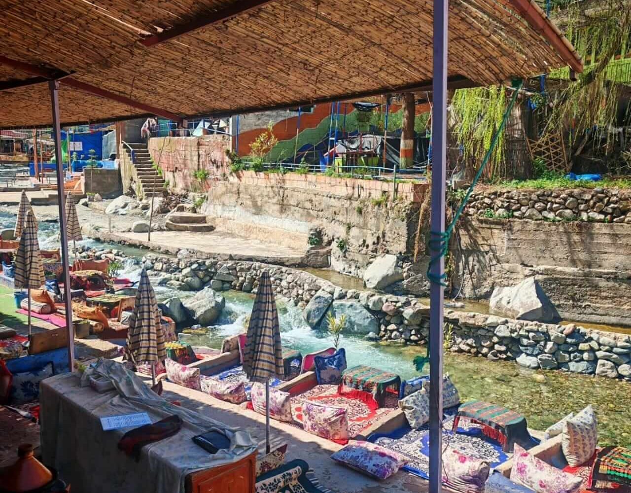 Low traditional seating under a thatched roof by the river