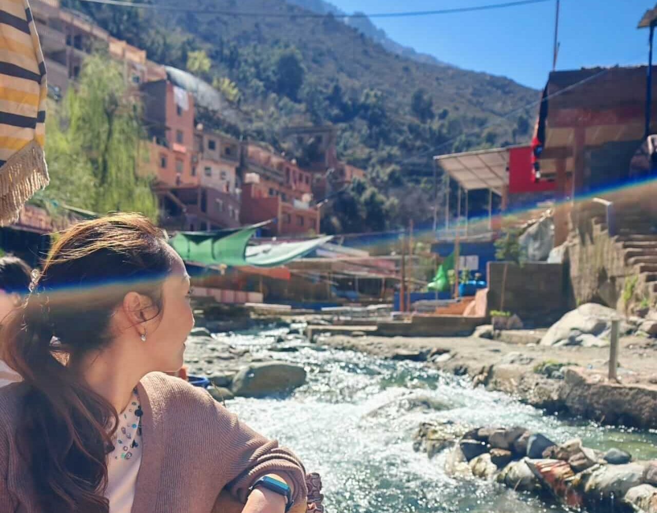 Visitor admiring the Ourika river with the village in the background