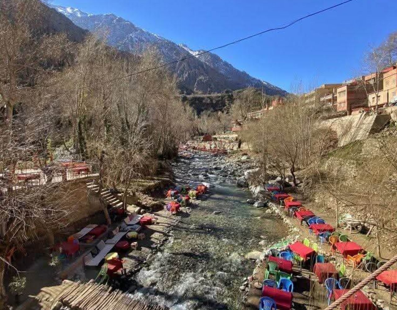 Zipline cable over Ourika Valley above red umbrella seating